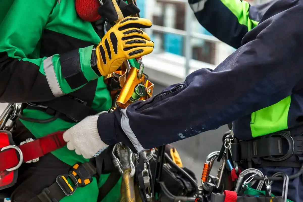 Doi alpiniști utilitari care își verifică reciproc echipamentul